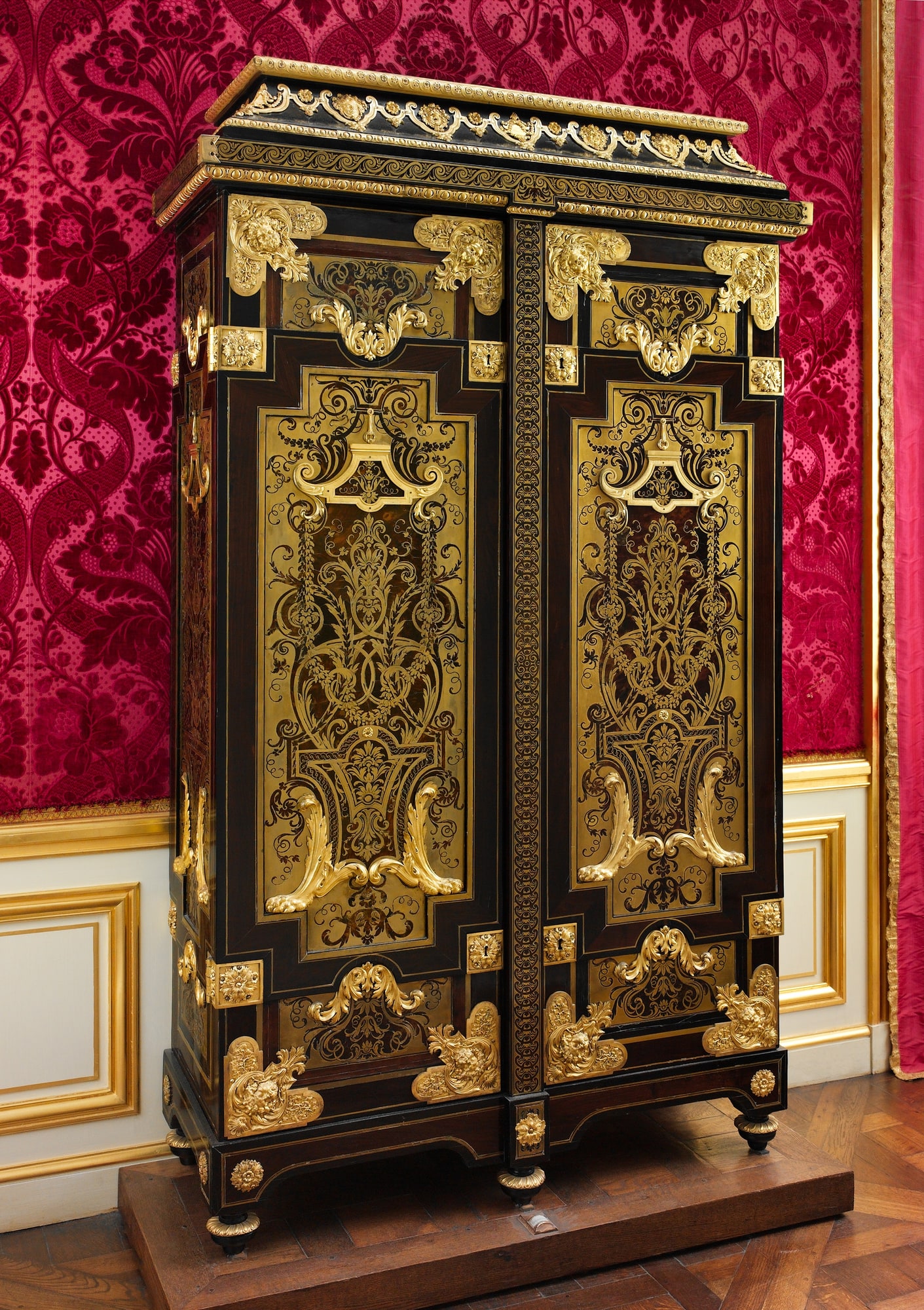 A tall cabinet attributed to André-Charles Boulle, covered with brass and tortoiseshell marquetry and gilt-bronze mounts.
